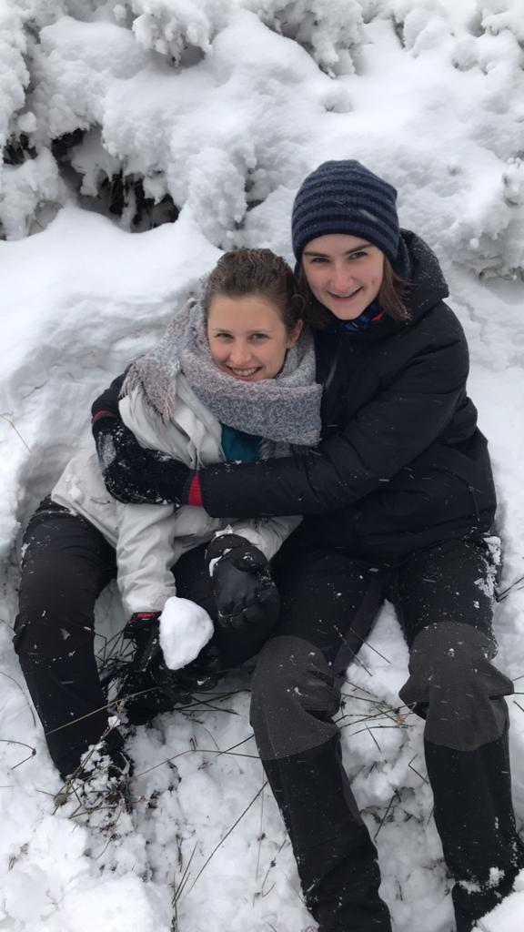 Audrey und Nina sitzten gemeinsam im Schnee