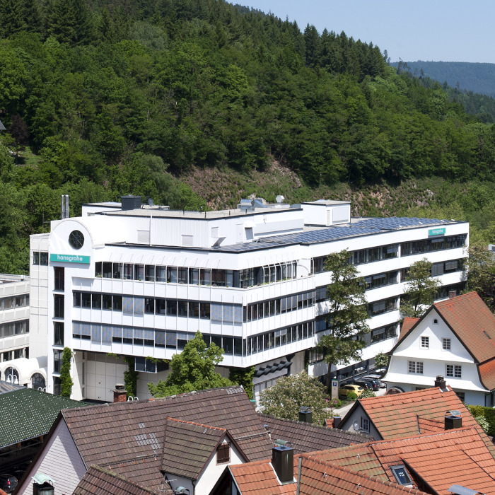 Hauptgebäude des Firmensitzes der Hansgrohe SE in Schiltach. Wald im Hintergrund. 