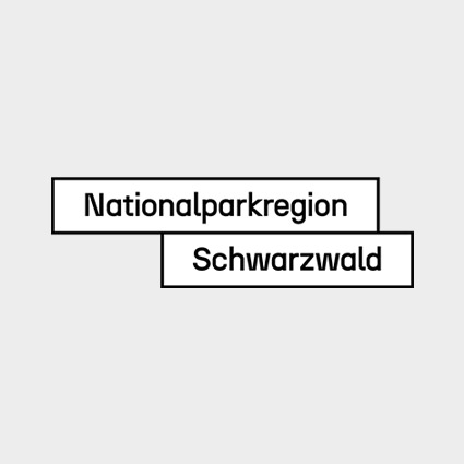 Das Logo der Nationalparkregion vor einem Bild der Schwarzwaldberge. Das Logo besteht aus dem Logo des Nationalparks, drei stilisierten Bergen in Grüntönen und dem "Nationalpark|Region Schwarzwald". Das Wort Region ist als einziges grün geschrieben.  