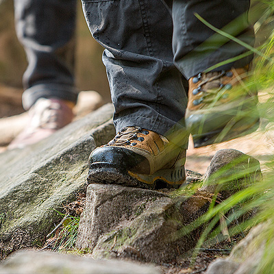 Detailaufnahme von Wanderschuhen auf einem steinigen Pfad