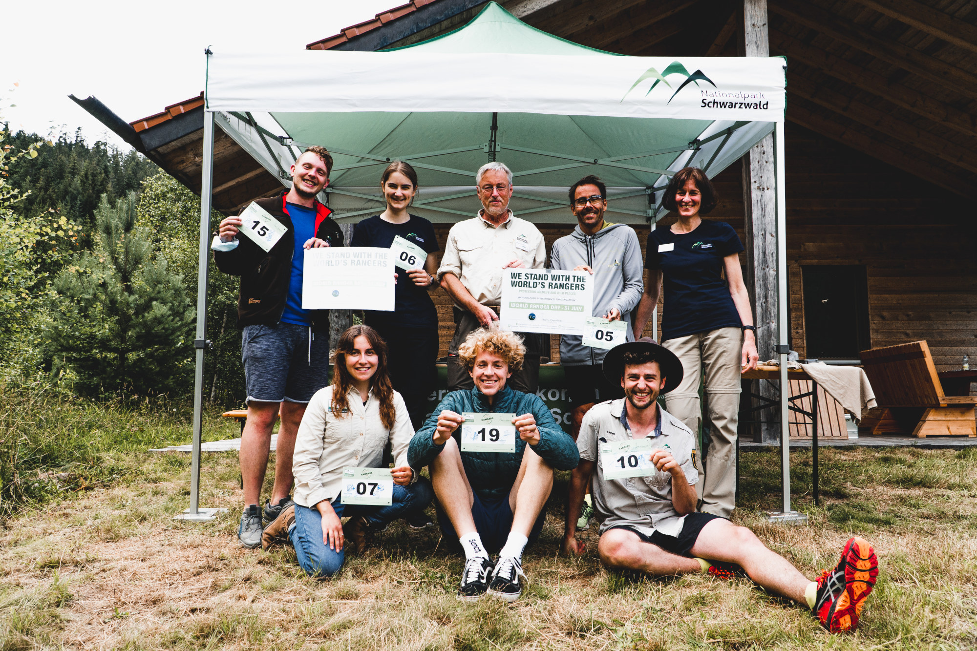 Spendenlauf am World Ranger Day. © Nicolas Ebert (Nationalpark Schwarzwald) Gruppenbild mit zehn Läufern unter einem Pavillonzelt, die eine Urkunde in die Kamera halten. Die Aufschrift ist nicht zu entziffern.