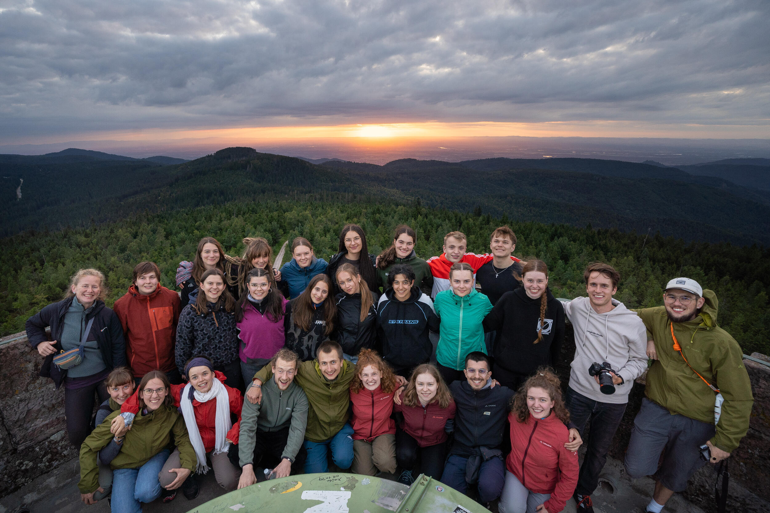 Ein Gruppenbild: Teilnehmer des Young Explorer Camps vor einem Sonnenuntergang. Foto: Vanessa Peter