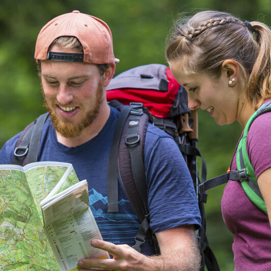 Zwei junge Erwachsene schauen auf eine Wanderkarte