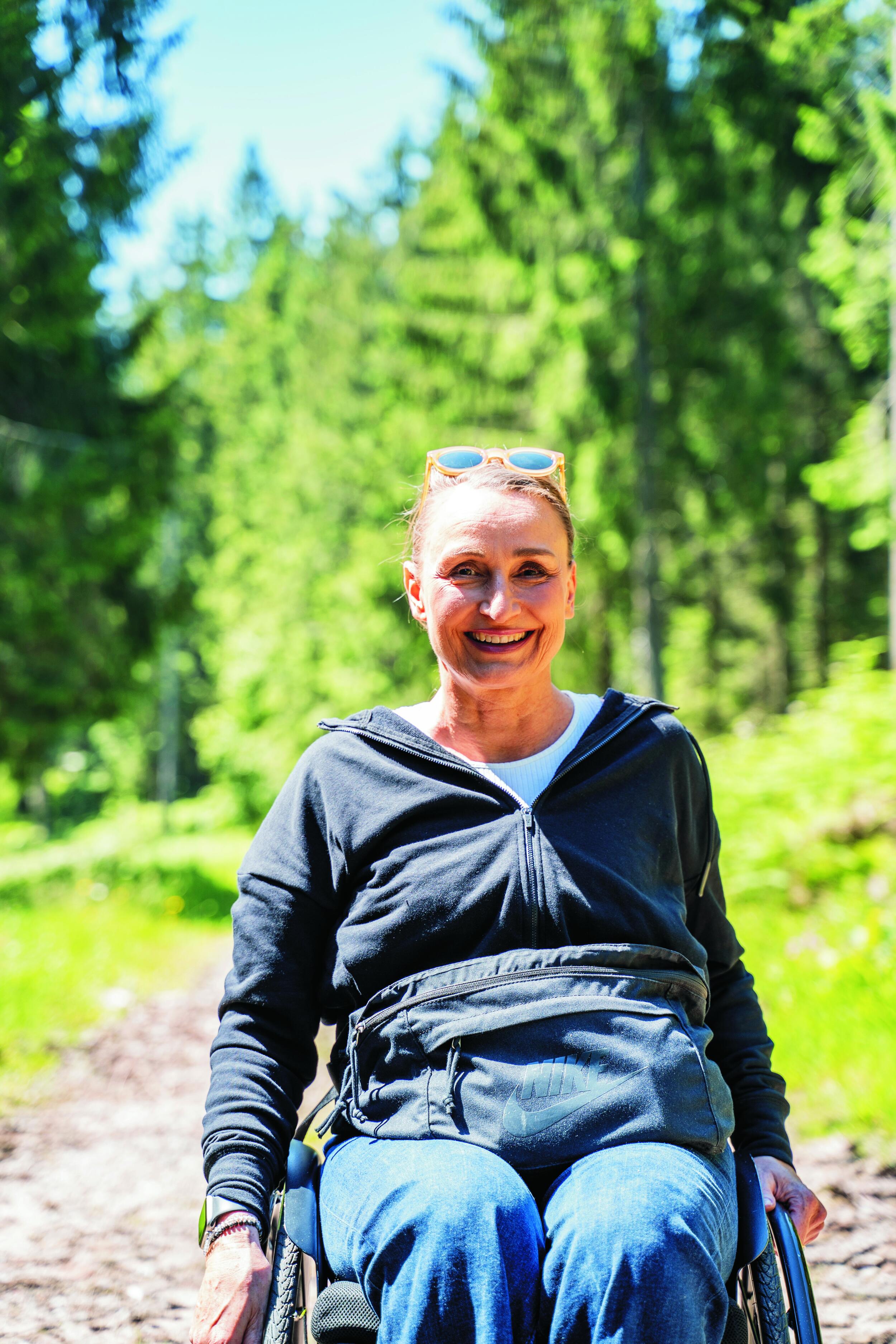 Sandra draußen auf einem Waldweg.