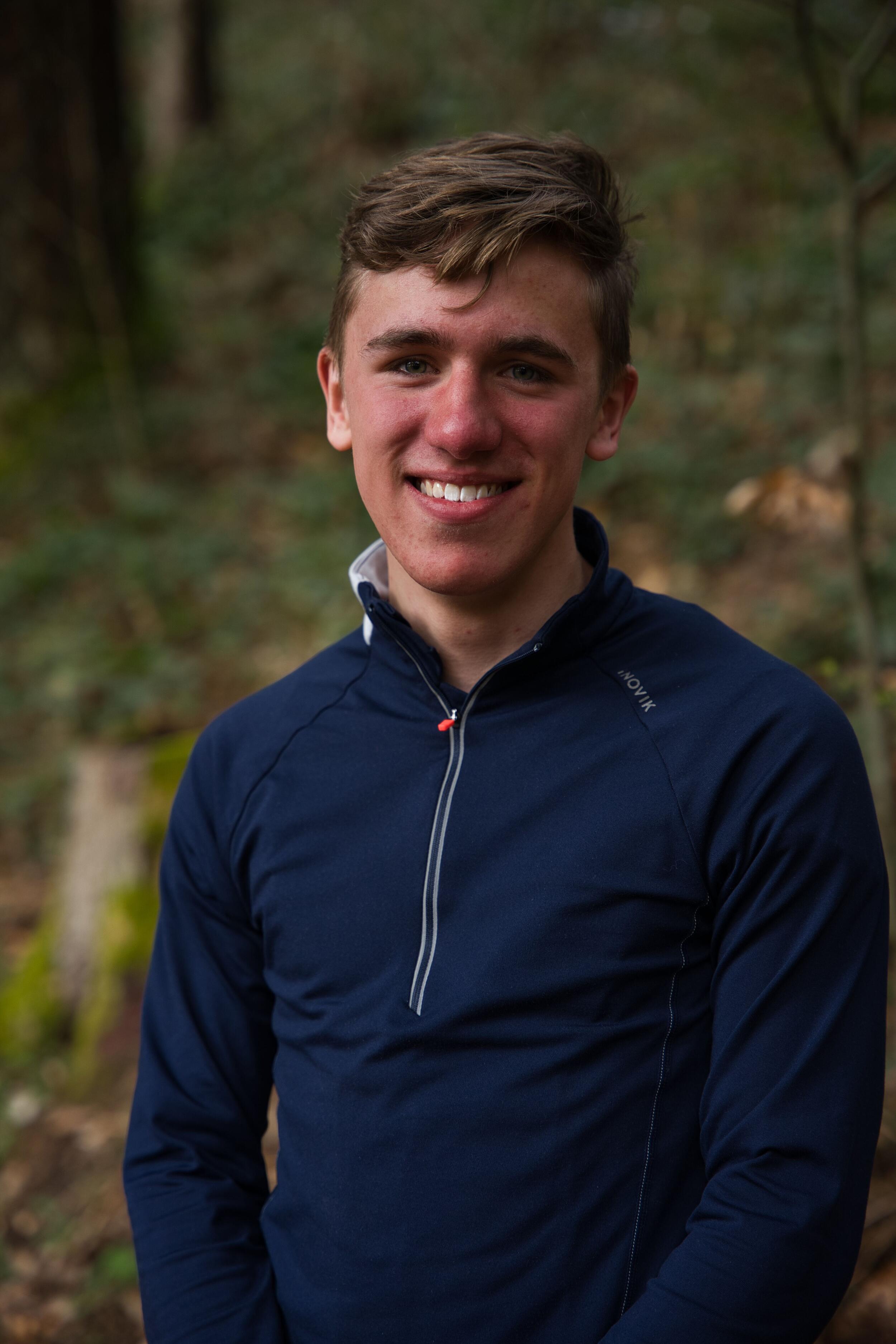 Ein junger Mann in einem dunkelblauen Shirt schaut lächelnd in die Kamera. Foto: Jonas Humm