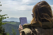 Frau liest im Unterwegs-FlyerFrau macht eine Pause auf dem Wanderweg - Foto: Daniel Müller (Nationalpark Schwarzwald)