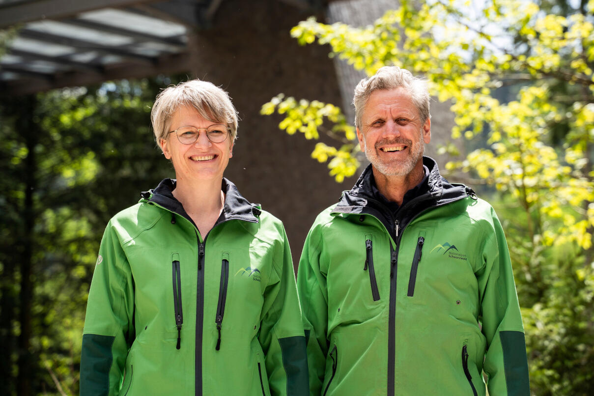 Eine Frau und ein Mann in grünen Jacken lächeln in die Kamera. Foto: Daniel Müller