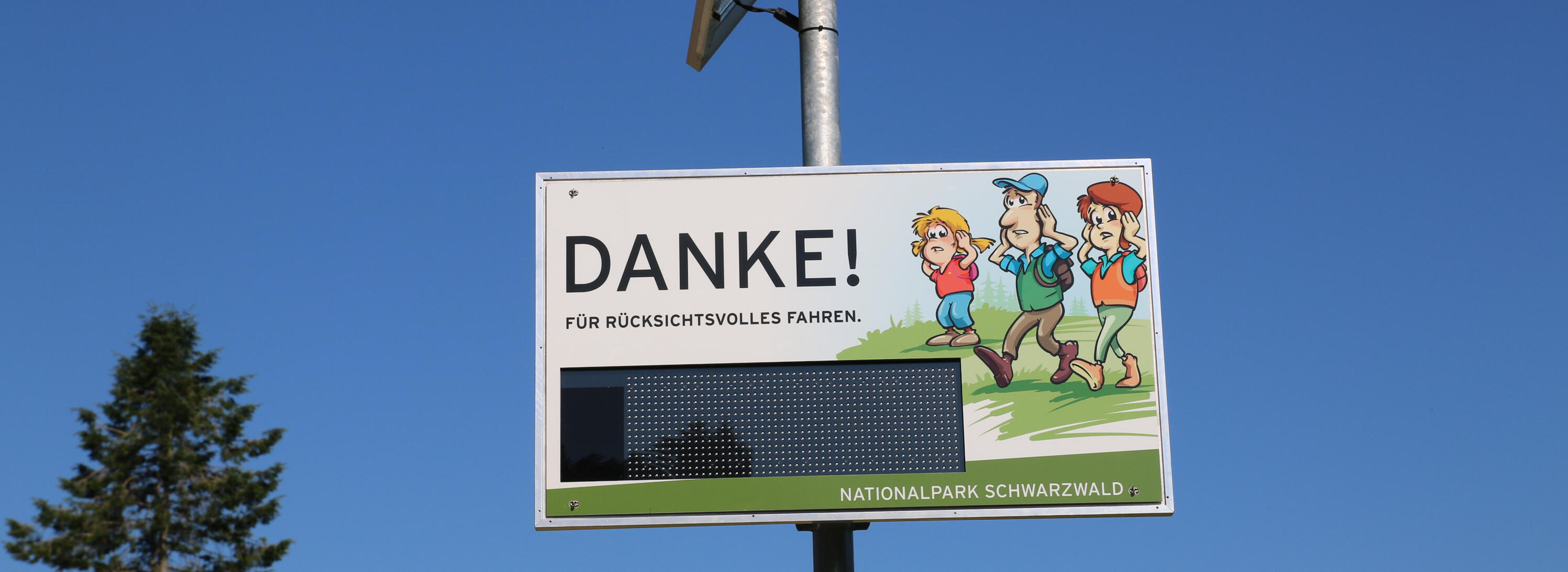 Eine Anzeigetafel mit der Aufschrift "Danke!" und einer Zeichnung mit drei Menschen. Sie halten sich die Ohren mit den Händen zu. Foto: Ekaterina Nastah (Nationalpark Schwarzwald)