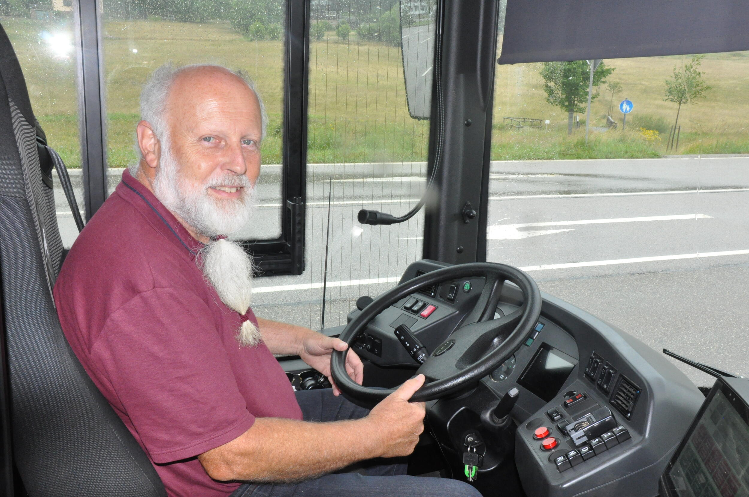 Keksübergabe im Bus. © Iris Lemanczyk Ein Busfahrer in dunkelrotem Hemd sitzt im Bus. Foto: Iris Lemanczyk