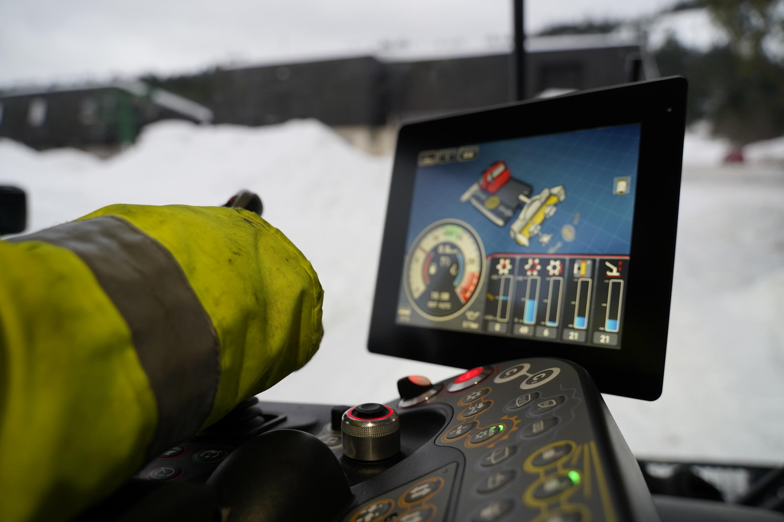 Ausschnitt einer Armatur im Pistenbully mit verschiedenen Tasten, Knöpfen und einem Bildschirm