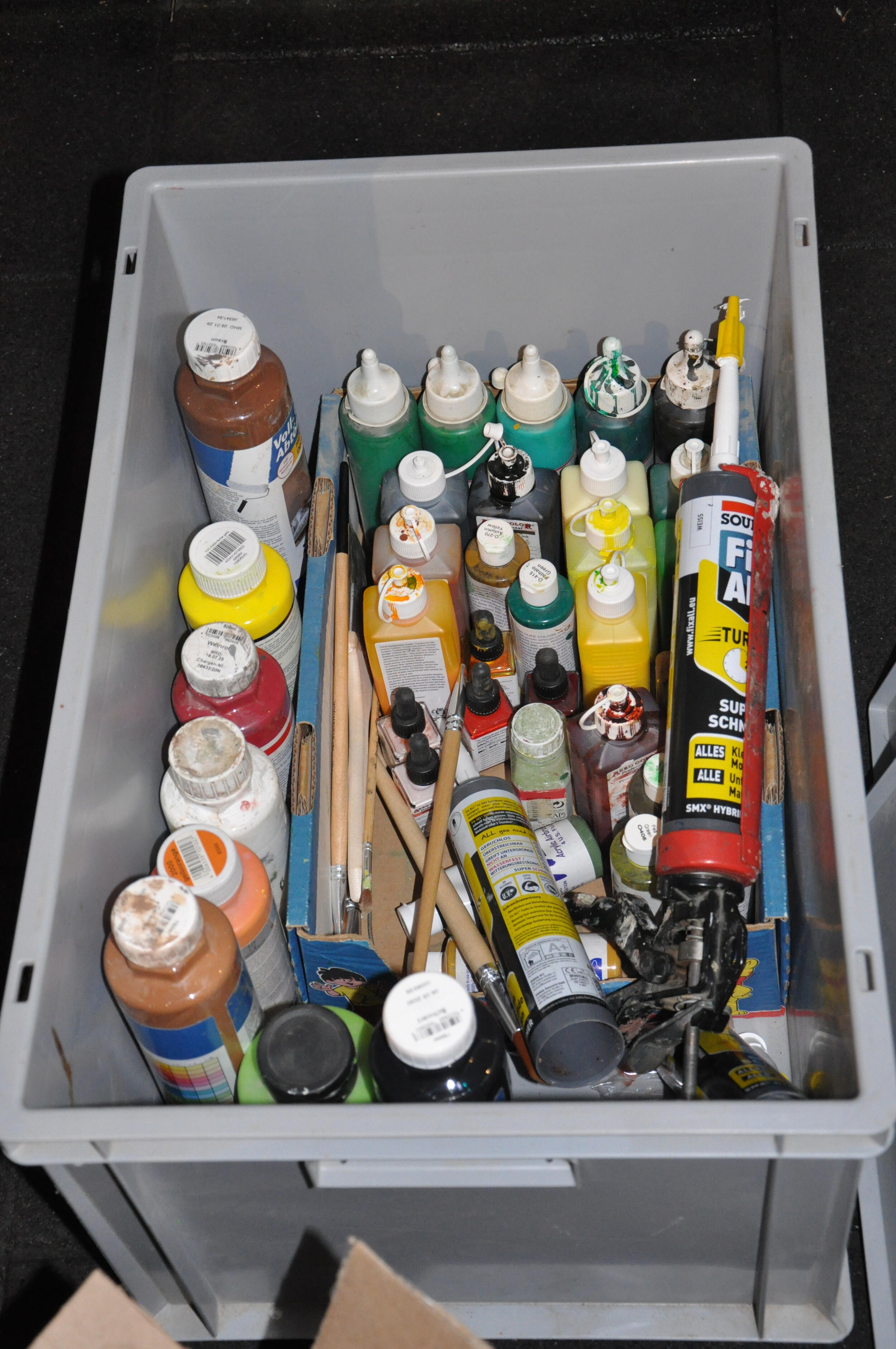 Eine Kiste mit vielen verschiedenen Farben und Pinseln. Foto: Iris Lemanczyk 