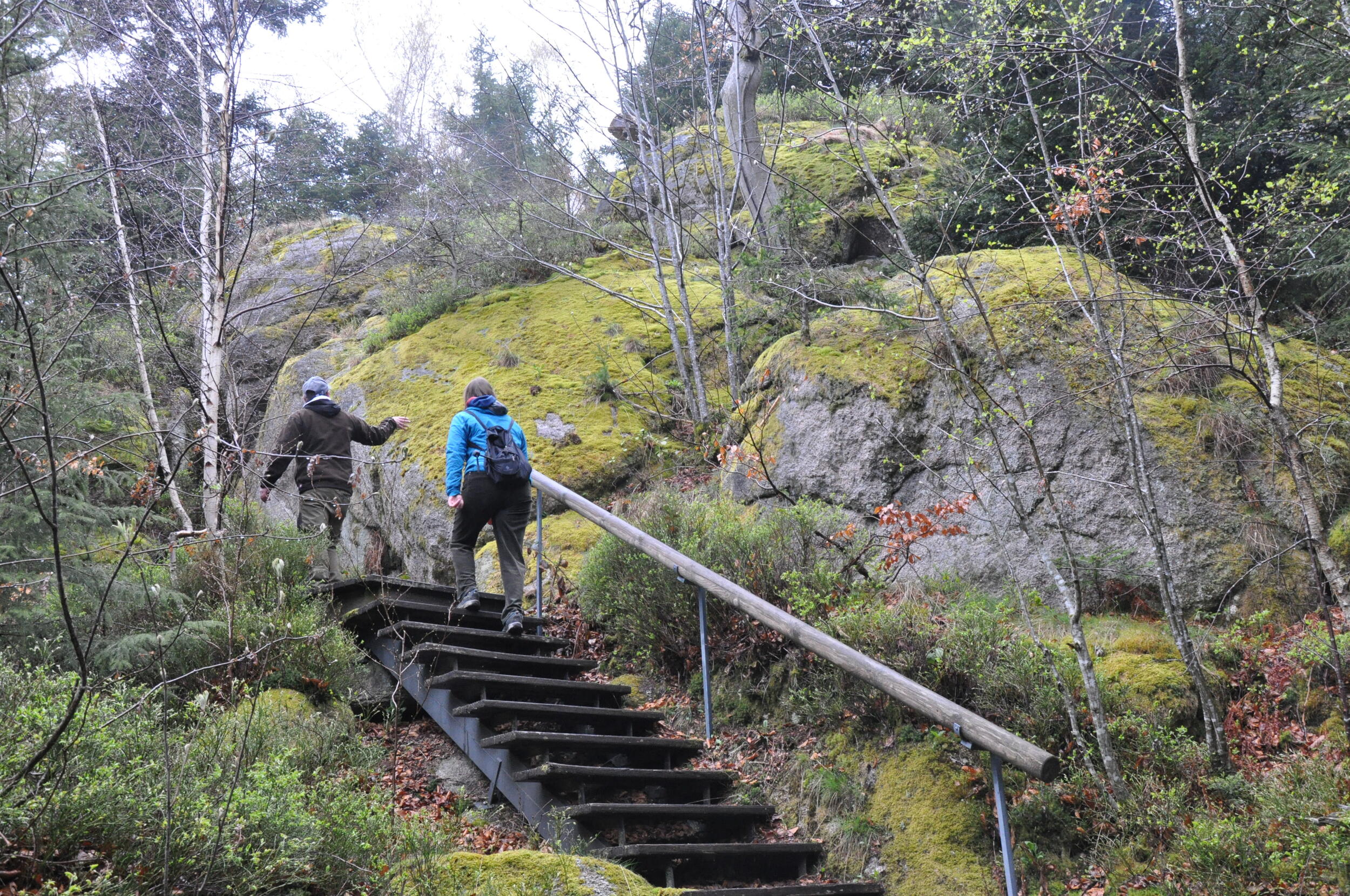 Treppen führen einen schmalen Pfad an einer Felswand entlang