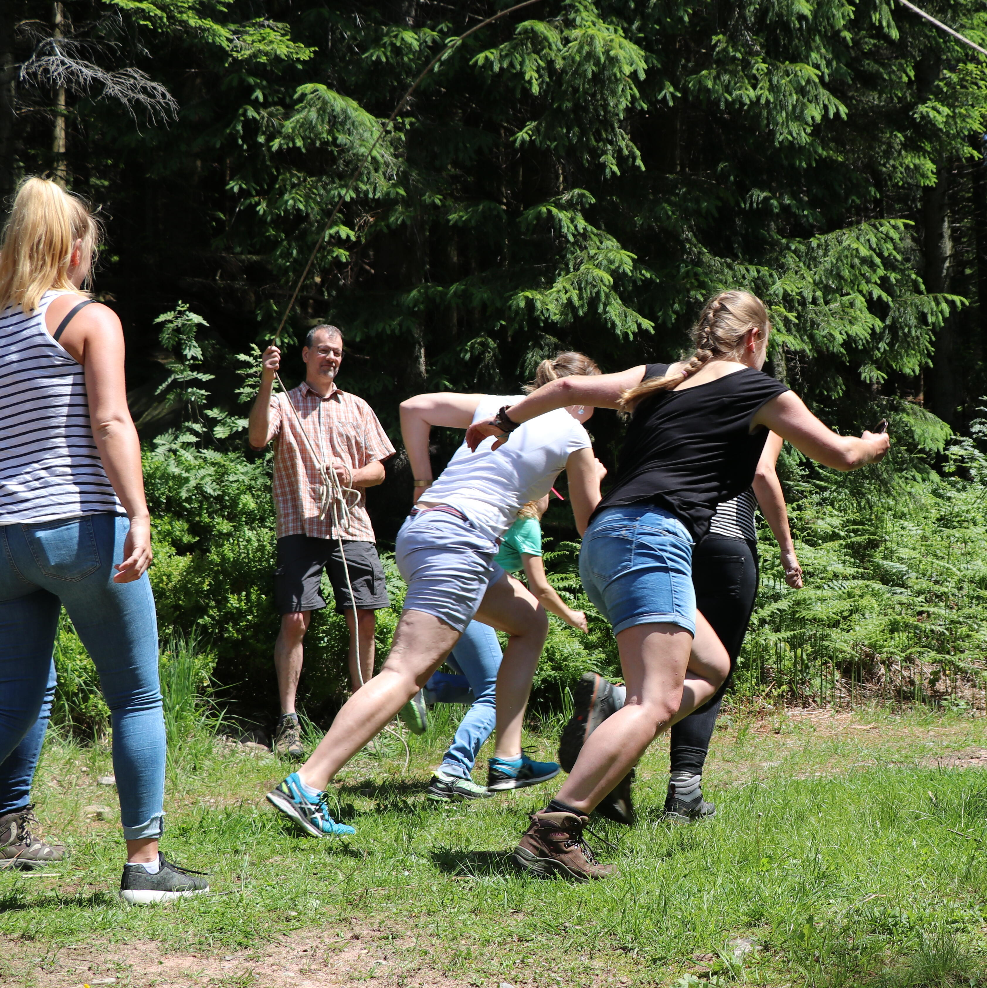 junge Erwachsene rennen unter einem schwingenden Seil hindurch © Matthias Eberspächer (Nationalpark Schwarzwald)