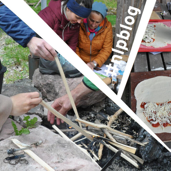 Hände mit Stöcken im Feuer, zwei Frauen in Outdoor-Kleidung, Teige mit Gemüse und Käse belegt