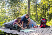 Pärchen studiert Karte auf einer Trekkingcamp-Plattform