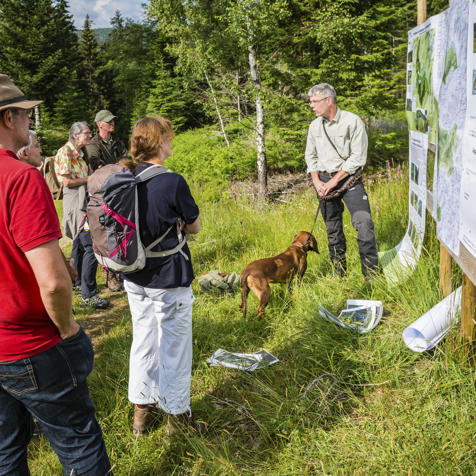 Nationalparkmitarbeiter steht vor einer Karte im Nationalpark