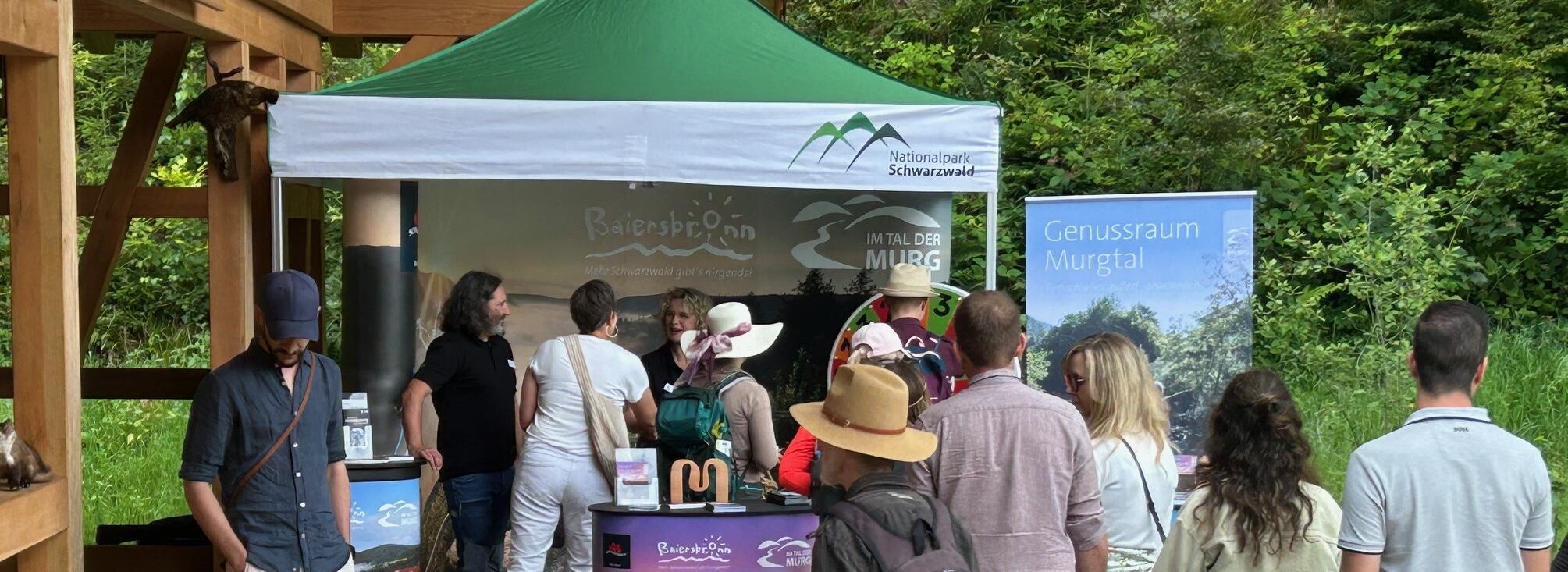 Eine Gruppe Menschen stehen vor einem Zelt mit der Aufschrift "Nationalpark Schwarzwald". Foto: Andreas Braun