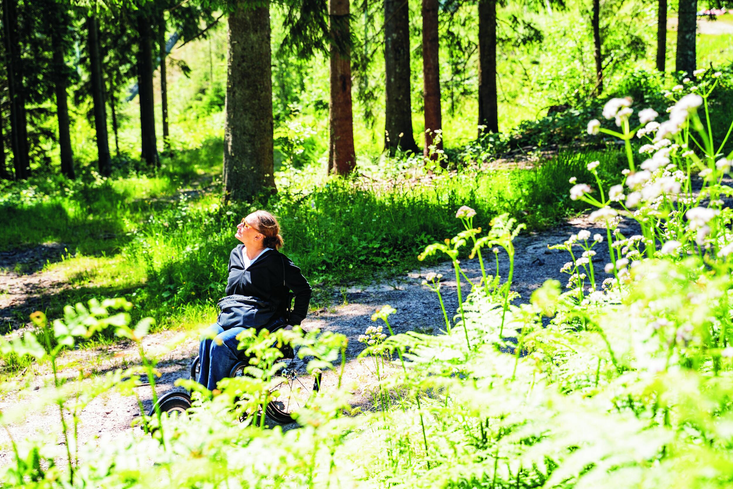Sandra auf einem breiten Weg im Wald.