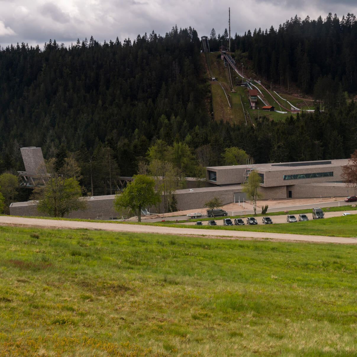 Aussenansicht Nationalparkzentrum: Großes Gebäude aus langen, mit Holzschindeln verkleideten Gebäuderiegeln.