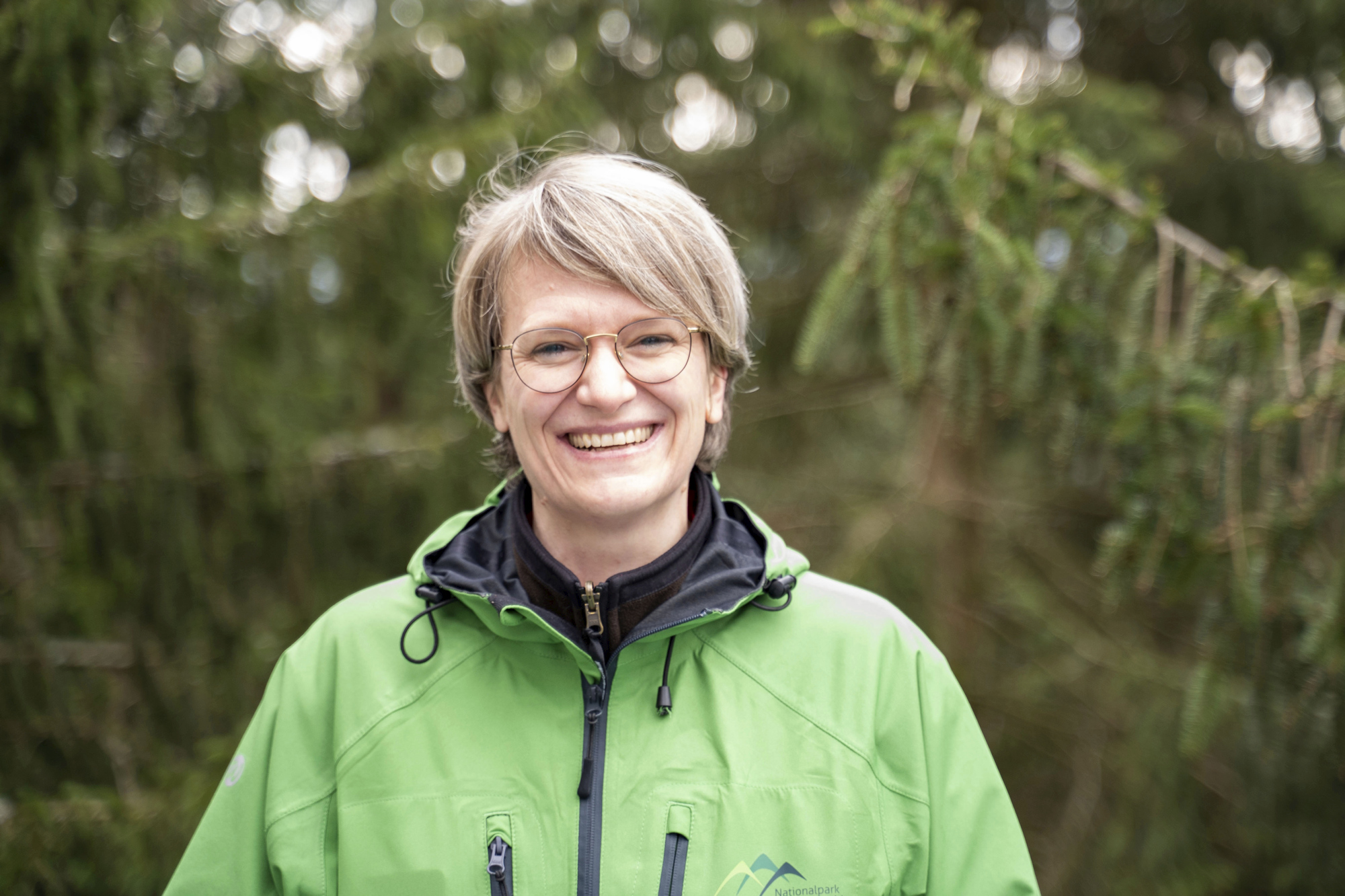 Eine Frau in grüner Jacke steht vor einer Waldkulisse. Foto: Daniel Müller (Nationalpark Schwarzwald)