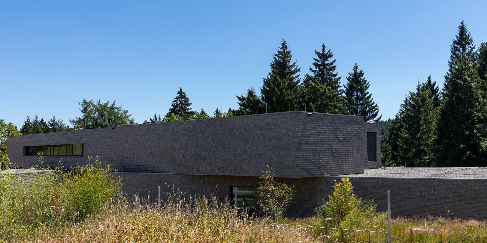 Die Nationalparkzentren am Ruhestein… © Iris Lemanczyk Großes Backsteingebäude vor dem Hintergrund einer Wiese. Foto: Iris Lemanczyk