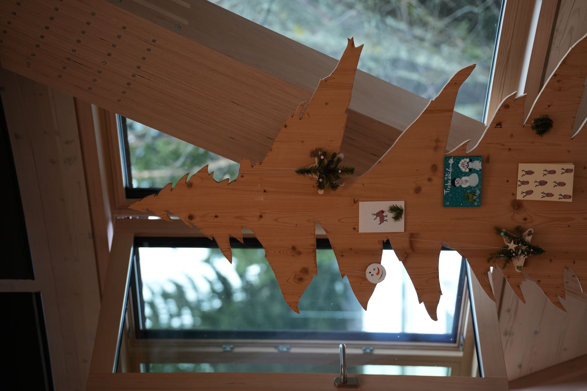 Man sieht einen Holzbaum mit weihnachtlichen Postkarten und Dekorationen. Foto: Ekaterina Nastah