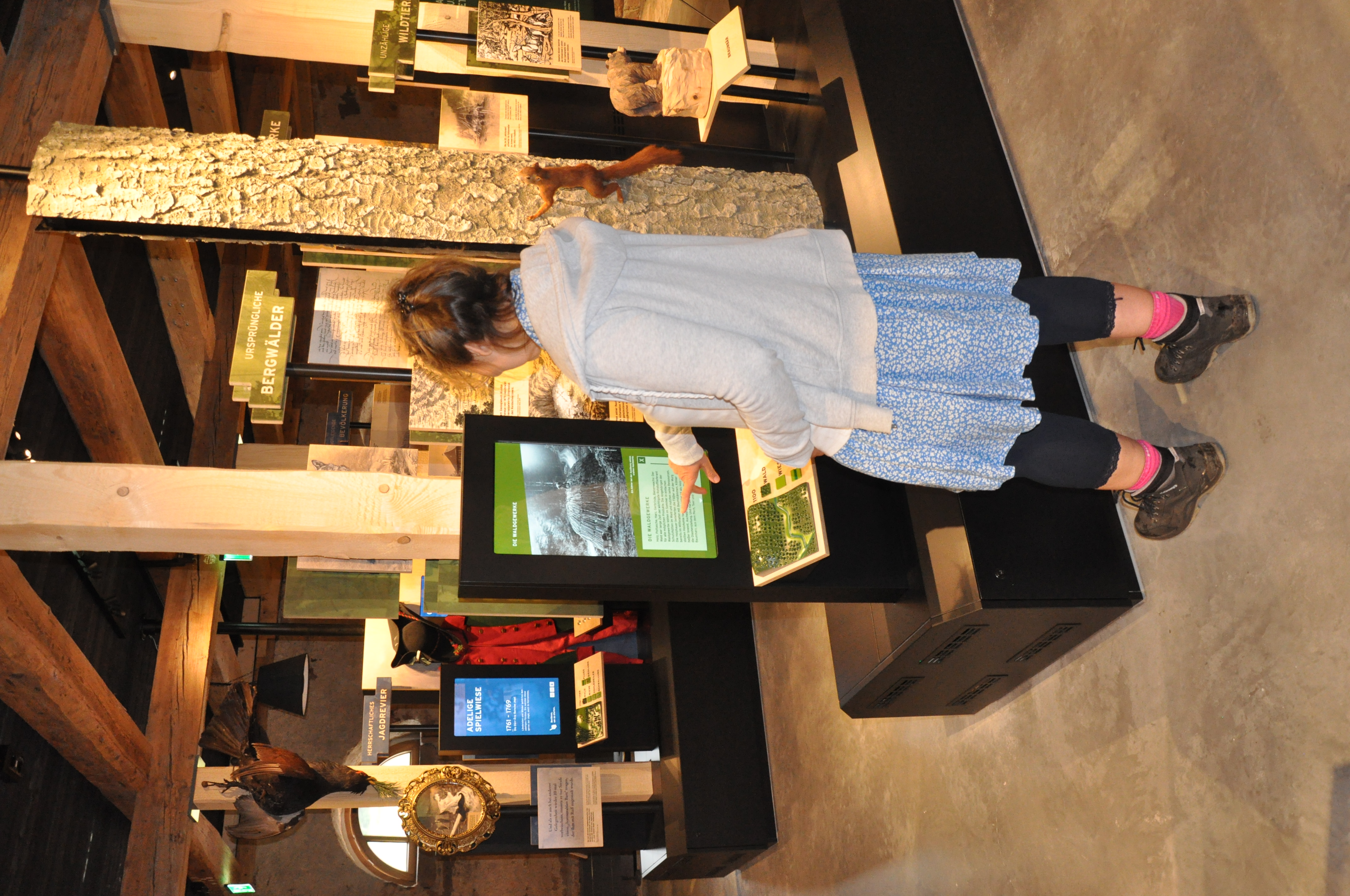 Eine Frau steht vor einem Bildschirm. Sie zeigt mit ihrem Finger auf eine digitale Tafel. Foto: Iris Lemanczyk 