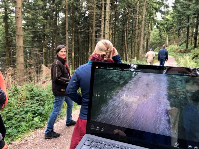 Aufnahme der Eyetracking-Brille auf einem Wanderweg im Nationalpark Ein Laptop im Vordergrund, einige Menschen laufen davor auf einem Weg. Foto: Eyetracking-Brille