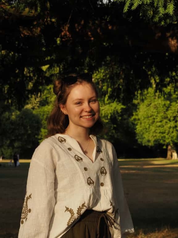 Eine junge Frau in beigem Hemd lächelt in die Kamera. Foto: Luisa Wiggers